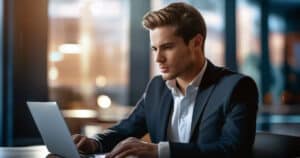 Young professional man in office using laptop